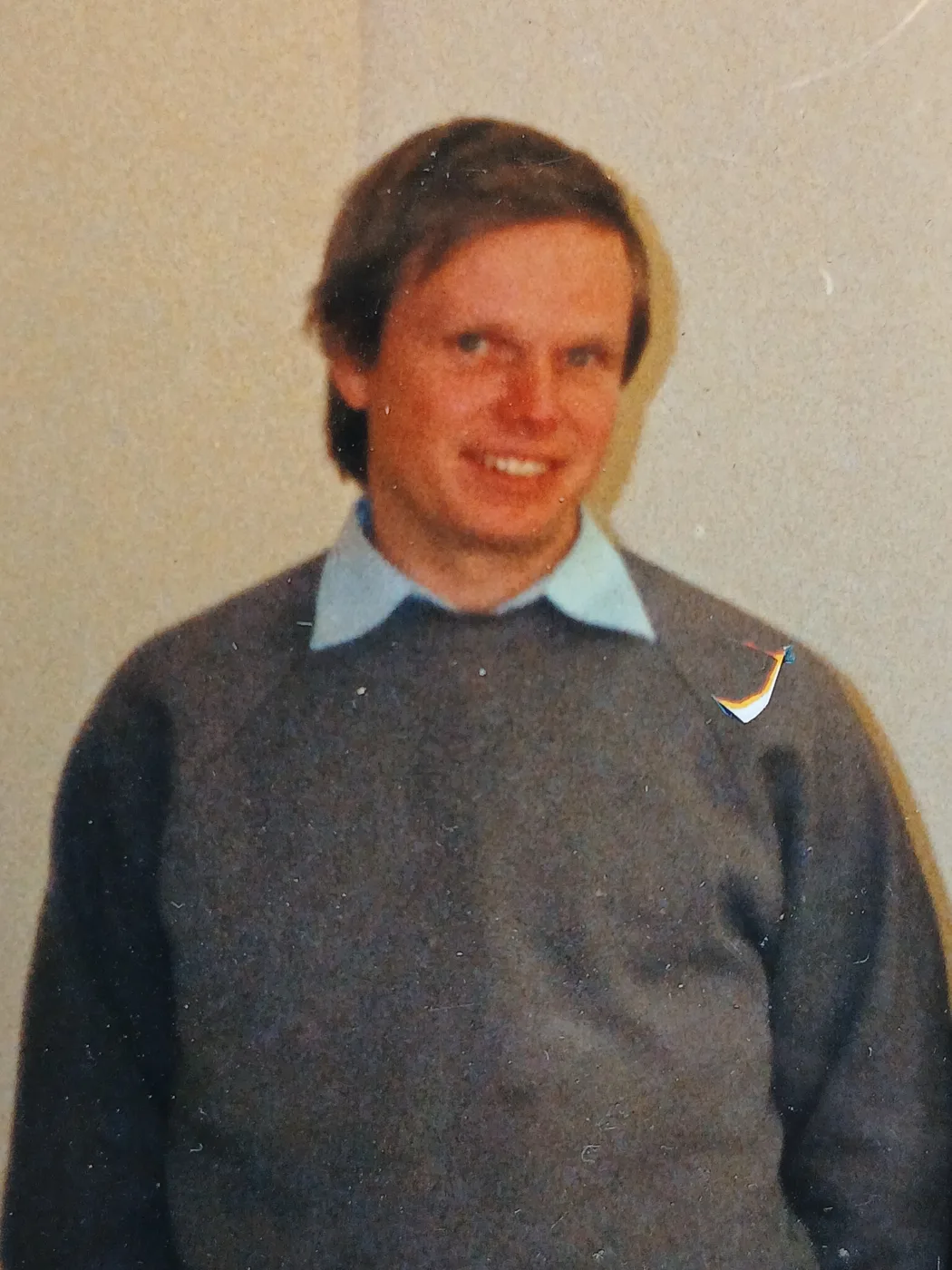 Terry Ridyard, smiling, in a grey jumper over a light blue collared shirt